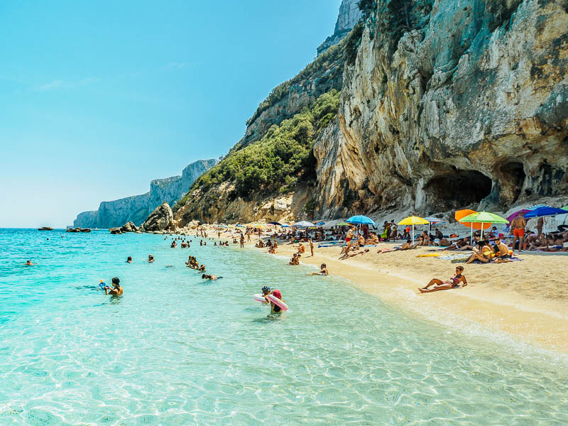 Crystal clear turquoise waters at Cala Luna beach with white limestone cliffs